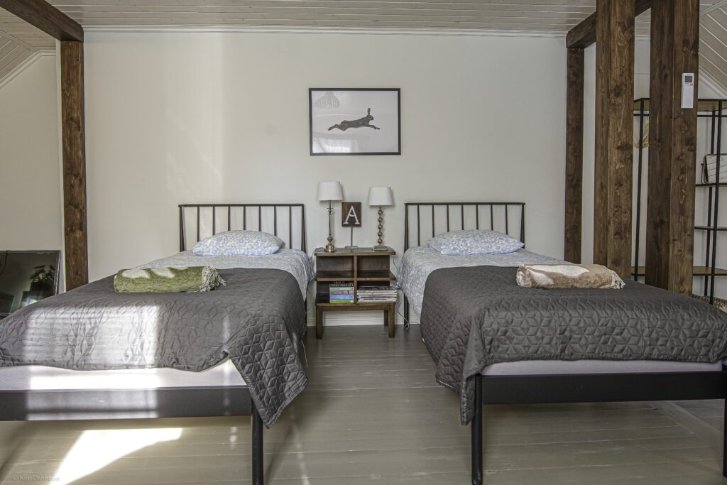 Kaksi erillistä sänkyä yläkerran makuutilassa Nyback Torpissa Tammisaaressa.